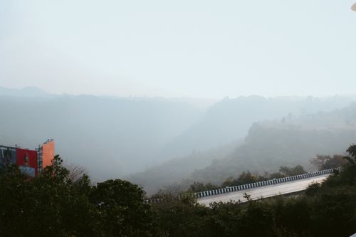 Free Peaceful mountain road enveloped in fog, offering a tranquil and atmospheric landscape view. Stock Photo