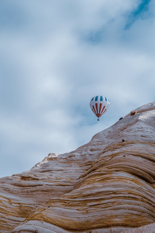 Hot Air Balloon in Air over Mountainside