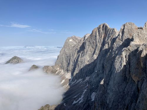 Free A stunning aerial view of rugged mountain peaks rising above a sea of clouds. Stock Photo