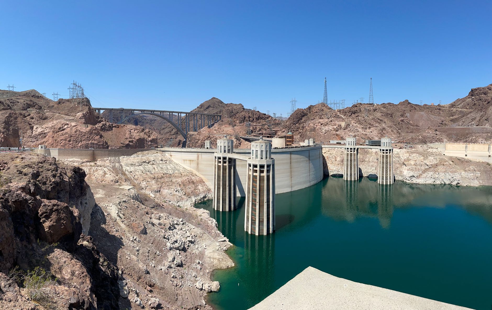 Stunning view of the Hoover Dam and bridge in a rocky desert landscape under a clear blue sky.