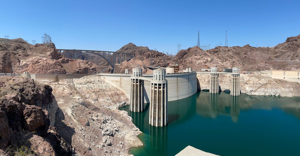 Stunning view of the Hoover Dam and bridge in a rocky desert landscape under a clear blue sky.
