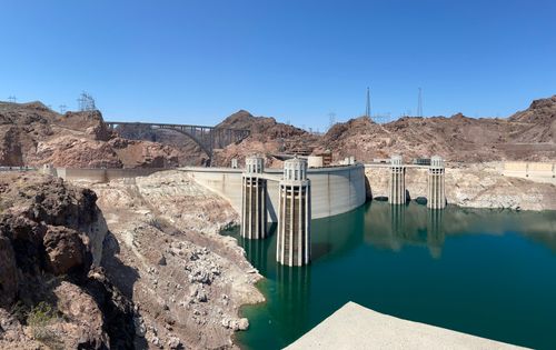 Free Stunning view of the Hoover Dam and bridge in a rocky desert landscape under a clear blue sky. Stock Photo