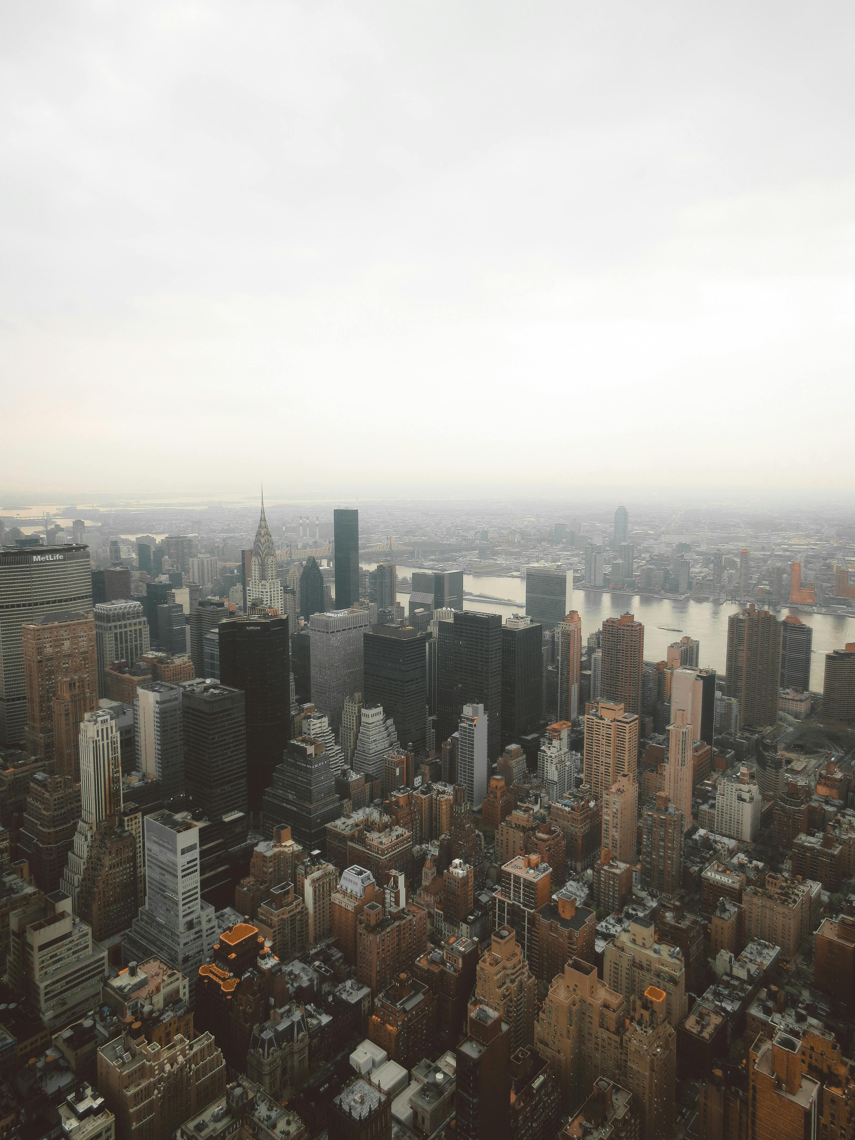 Stunning aerial view of New York City's skyline with skyscrapers and a calm cloudy sky.