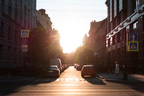 Free Dramatic street scene at sunset capturing silhouettes and warm urban life. Stock Photo