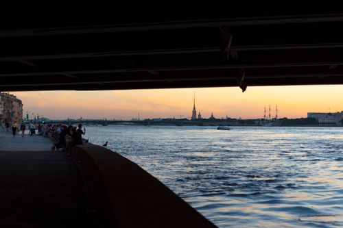Free A vibrant city promenade by the river at sunset, showcasing urban life and stunning skylines. Stock Photo