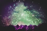 夜晚，人群在五彩缤纷的烟雾和明亮的灯光下，观看了令人惊叹的烟花表演