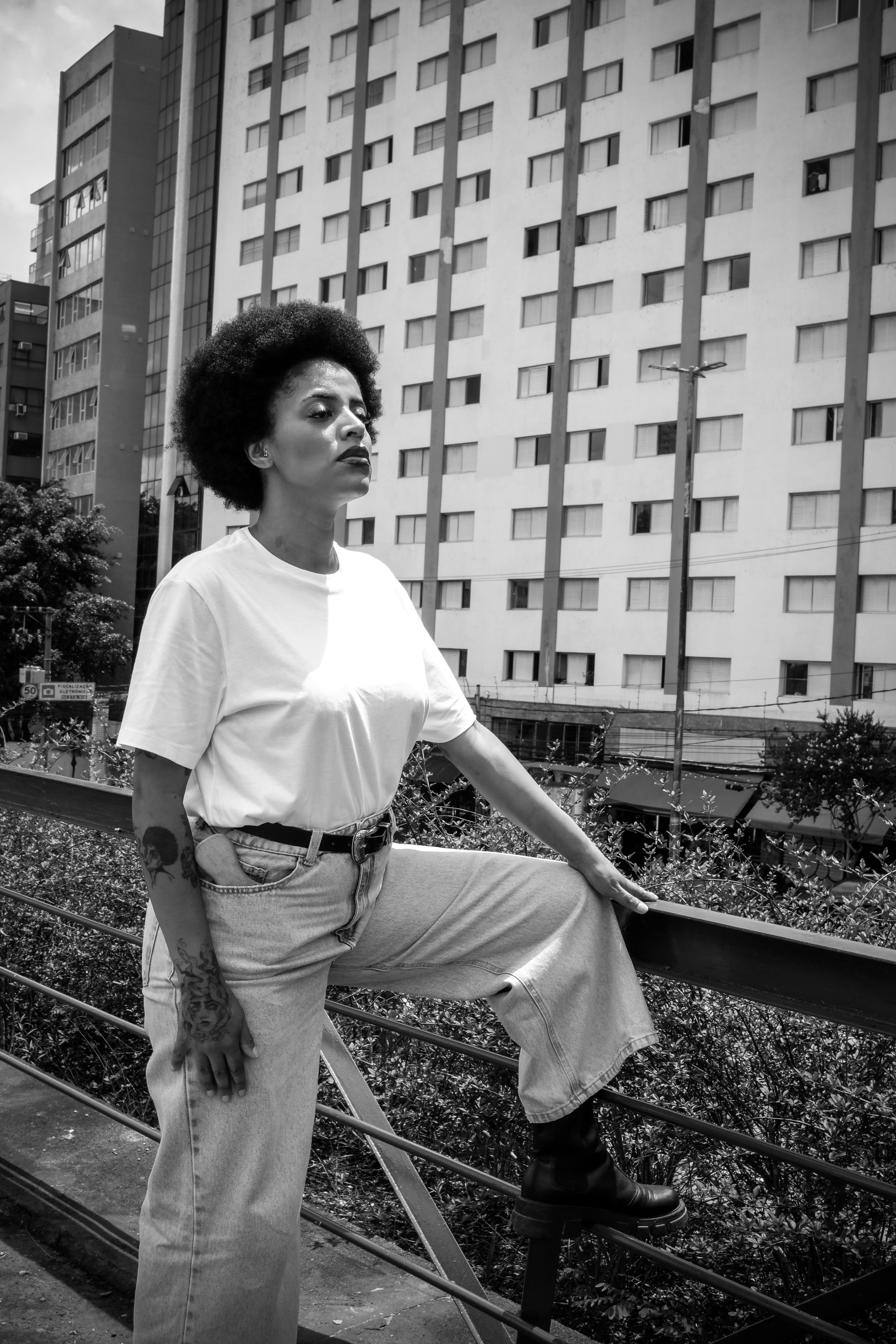 Stylish woman poses in Sao Paulo with modern architecture backdrop.