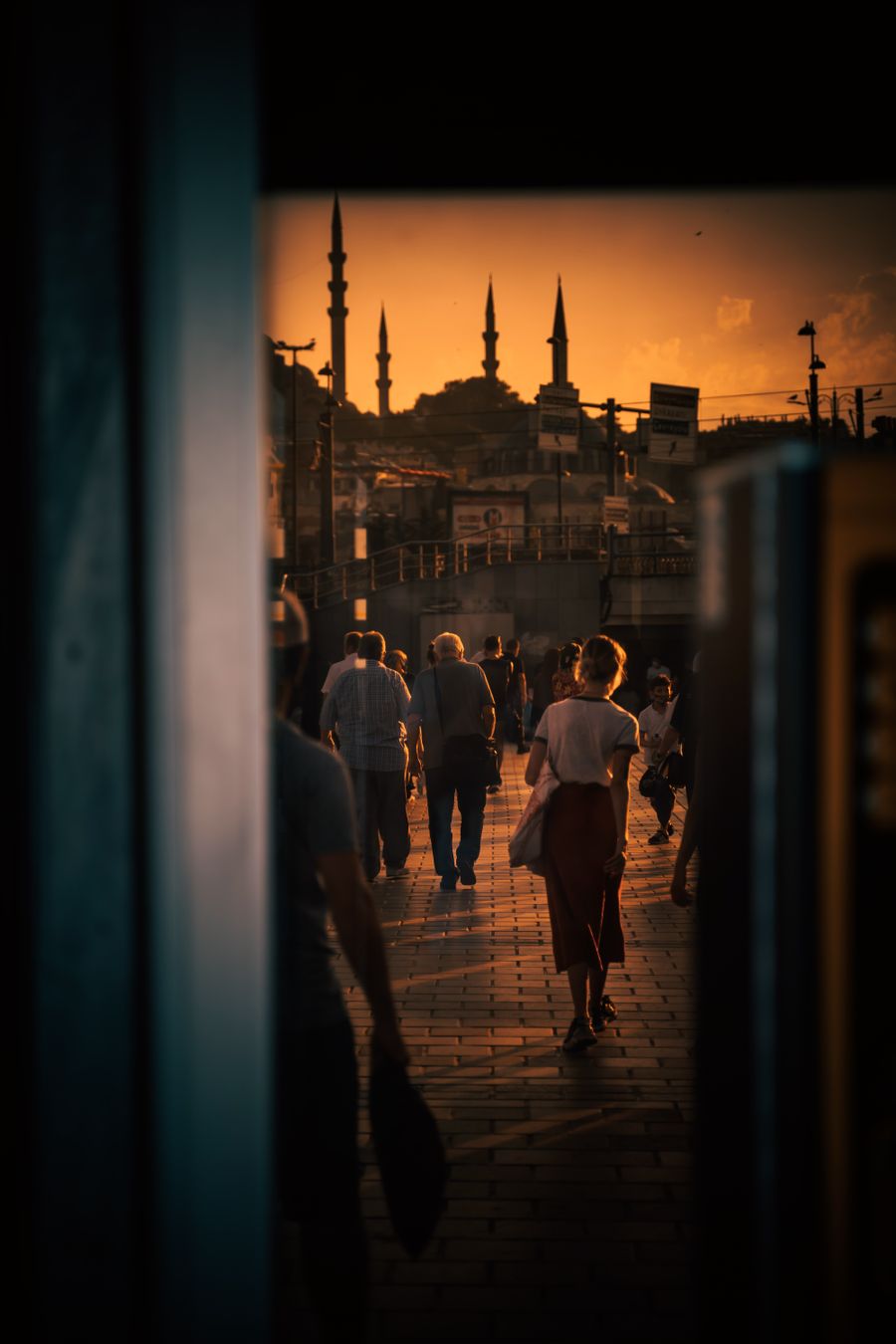 Şehir kaldırımında akşam vakti, gün batımına karşı minareler