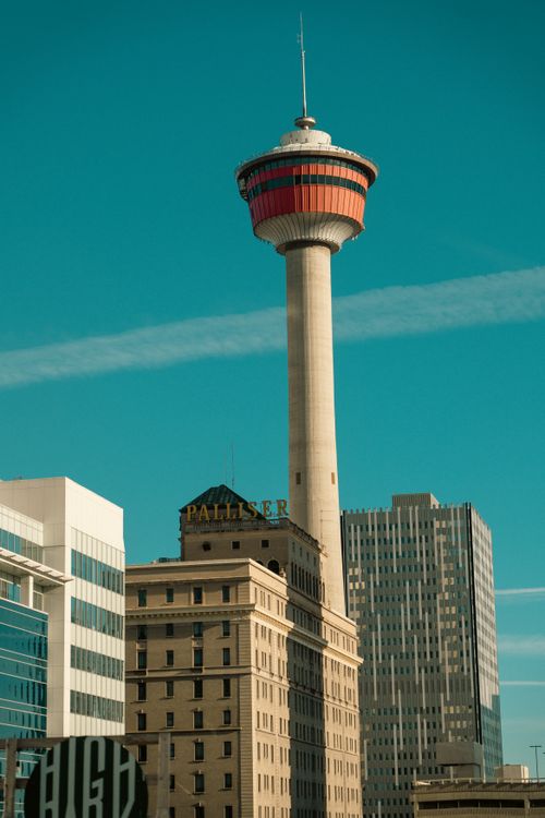Free Vertical shot of the iconic Calgary Tower surrounded by modern and classic architecture. Stock Photo