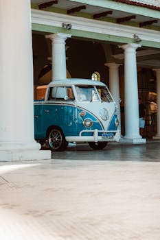 A vintage Volkswagen van parked among white colonial columns capturing a nostalgic vibe.
