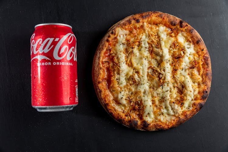 Overhead Shot Of A Pizza Beside A Coca Cola Can