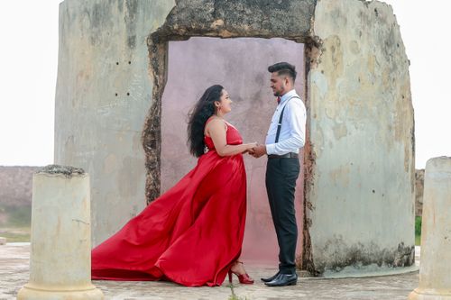 Free A couple in formal attire holds hands and shares an intimate moment outdoors. Stock Photo