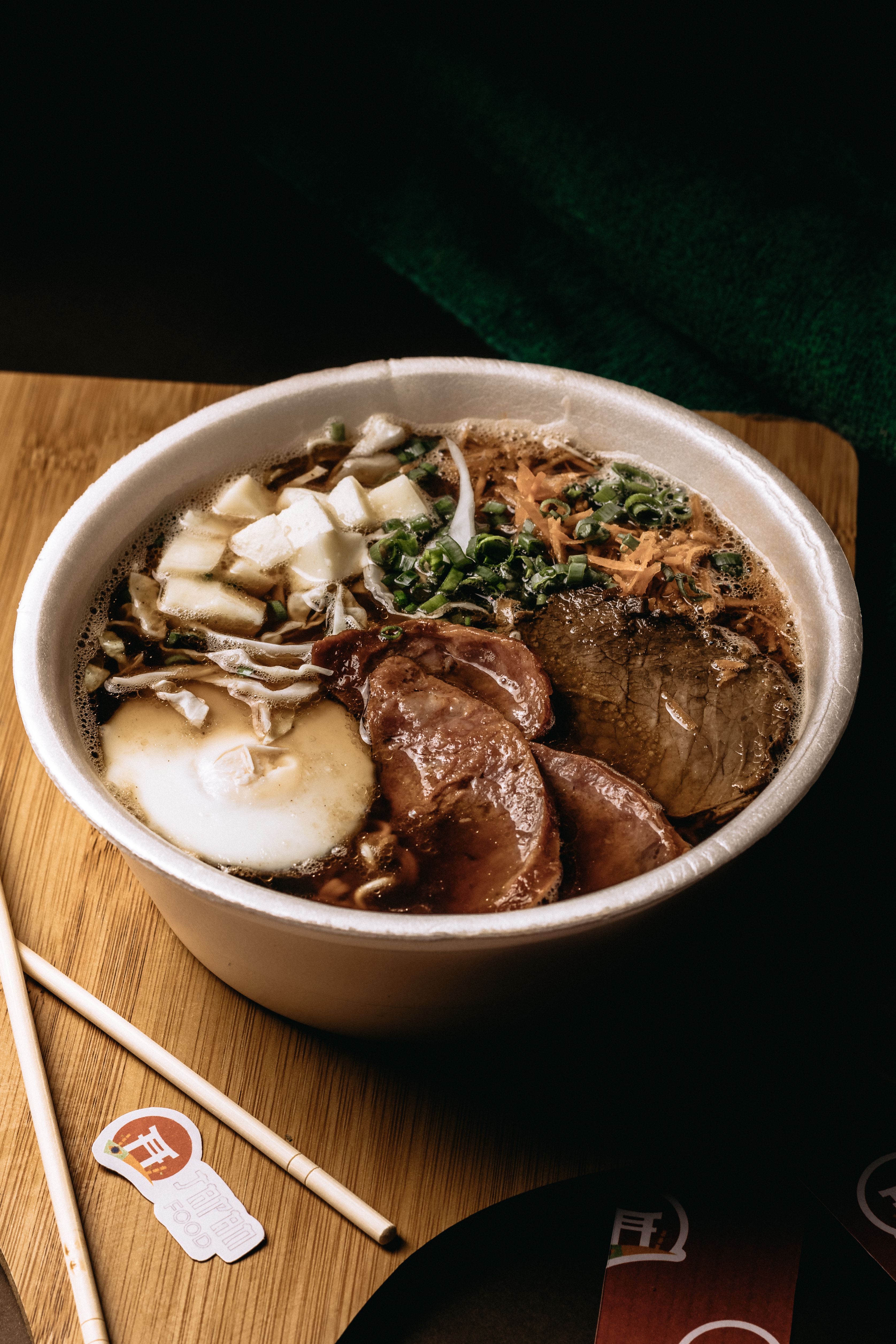 Close-up of a savory Japanese ramen bowl with various traditional toppings on a wooden surface.