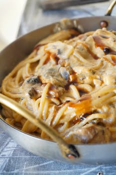Delicious creamy pasta with mushrooms served in a brass pan in Buenos Aires, Argentina.