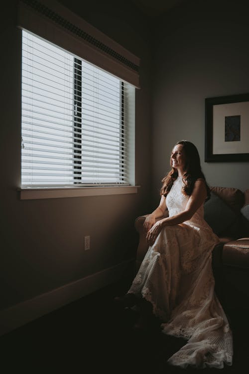 Woman in a Wedding Dress Sitting on a Sofa