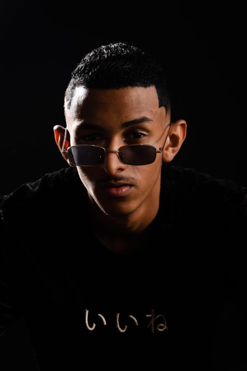 Free Close-up portrait of a young man in sunglasses with a dark background. Stock Photo