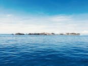 宁静的海景下，广阔的蓝天映衬着岩石岛屿，非常适合自然主题