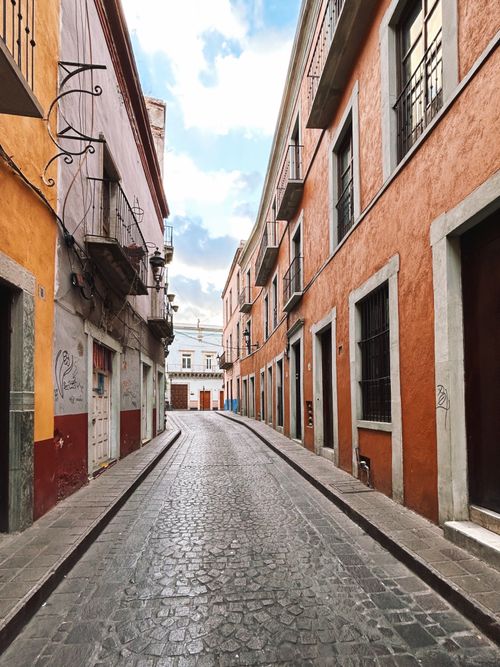 Free Colorful cobblestone street lined with vibrant buildings in Guanajuato, Mexico. Stock Photo