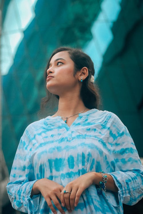 Brunette Woman in White and Blue Blouse Looking Up