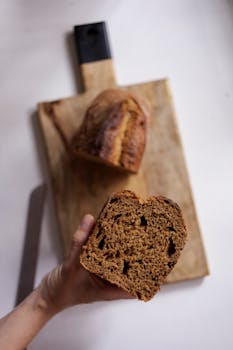 Artistic close-up of a loaf of bread on a wooden cutting board, ideal for food photography.