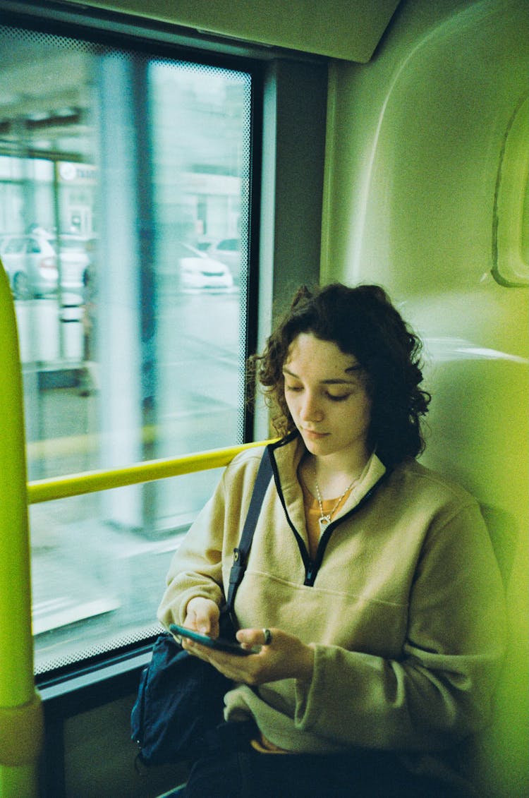 Woman With Cellphone Near Window