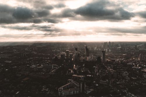 Free A dramatic aerial view of London cityscape under clouded sky, highlighting urban architecture. Stock Photo