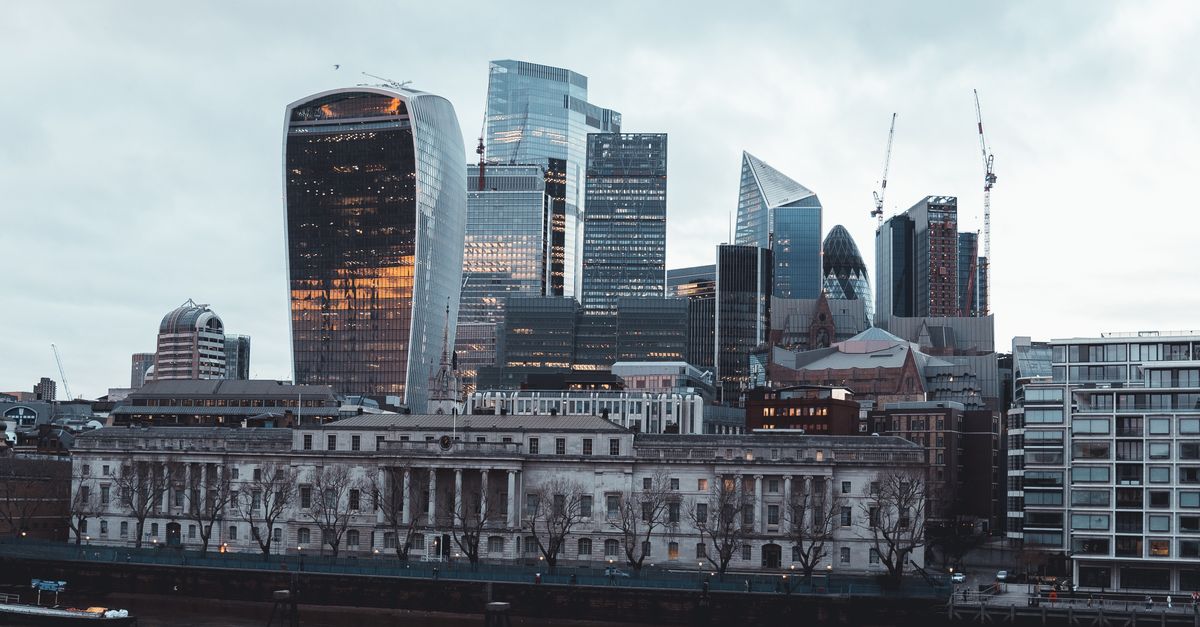 Dramatic view of London's modern skyscrapers with iconic architecture under a cloudy sky.