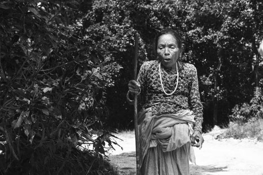 Senior woman with a walking stick in rural Kathmandu, Nepal.
