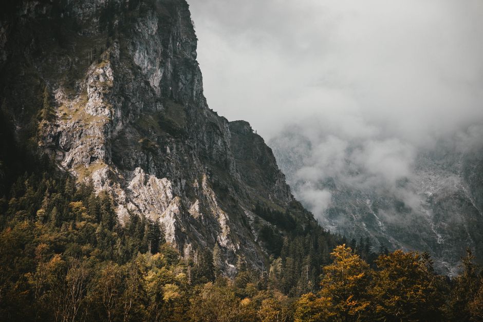 Mist-covered mountains and autumn forests in Berchtesgaden, Germany offer a dramatic scenery.