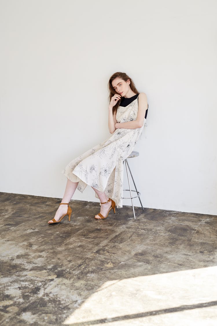 Woman In A Room Sitting On A Stool 