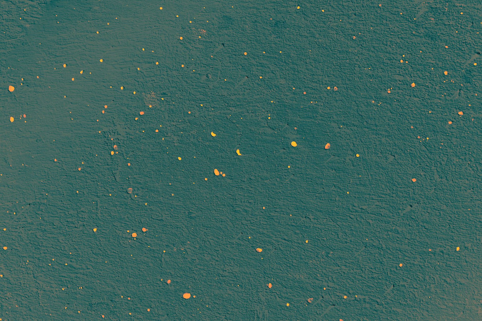 A vibrant abstract texture with yellow and orange dots on a green surface, ideal for creative projects.
