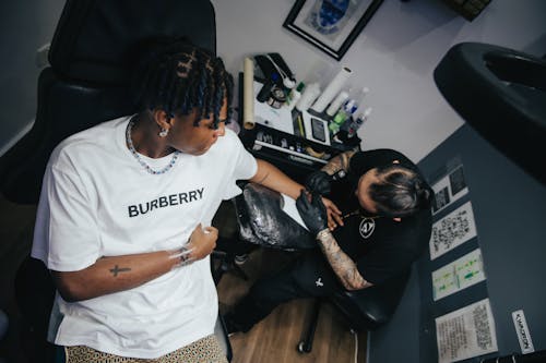 Foto profissional grátis de cabelo escuro, camiseta, estúdio de tatuagem