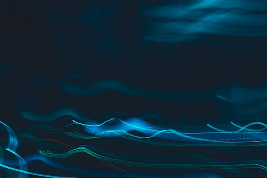 Dynamic abstract image of blue light streaks on a dark background, evoking motion and energy.