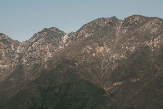 A tranquil view of rugged mountain ridges under clear skies in autumn.