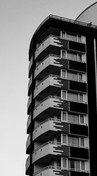 Dynamic black and white photo of a modern apartment building's exterior.