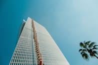 晴朗的天空下，棕榈树映衬着以色列拉马特甘一座现代摩天大楼的低角度视图