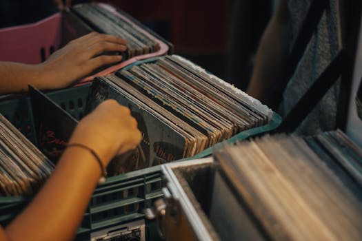 Hands exploring vintage vinyl records in a crate, showcasing nostalgic music culture.