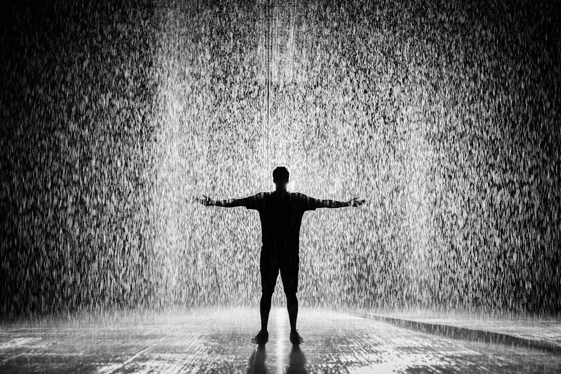 Silhouette and Grayscale Photography of Man Standing Under the Rain