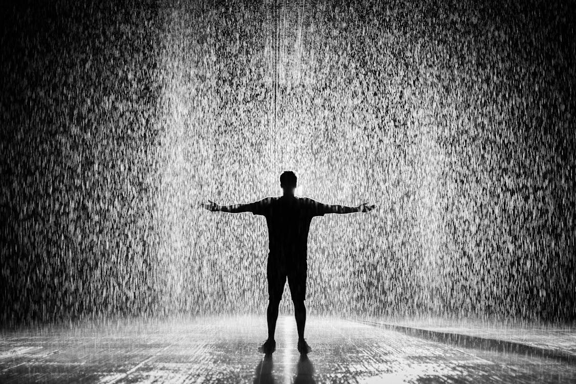 Fotografia De Silhuetas E Tons De Cinza De Um Homem Parado Sob A Chuva