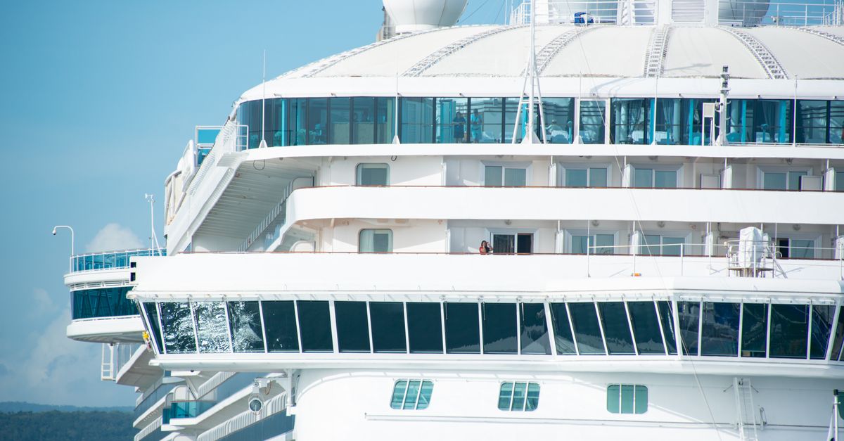 Detailed view of cruise ship exterior against a clear blue sky, showing windows and bright white structure.