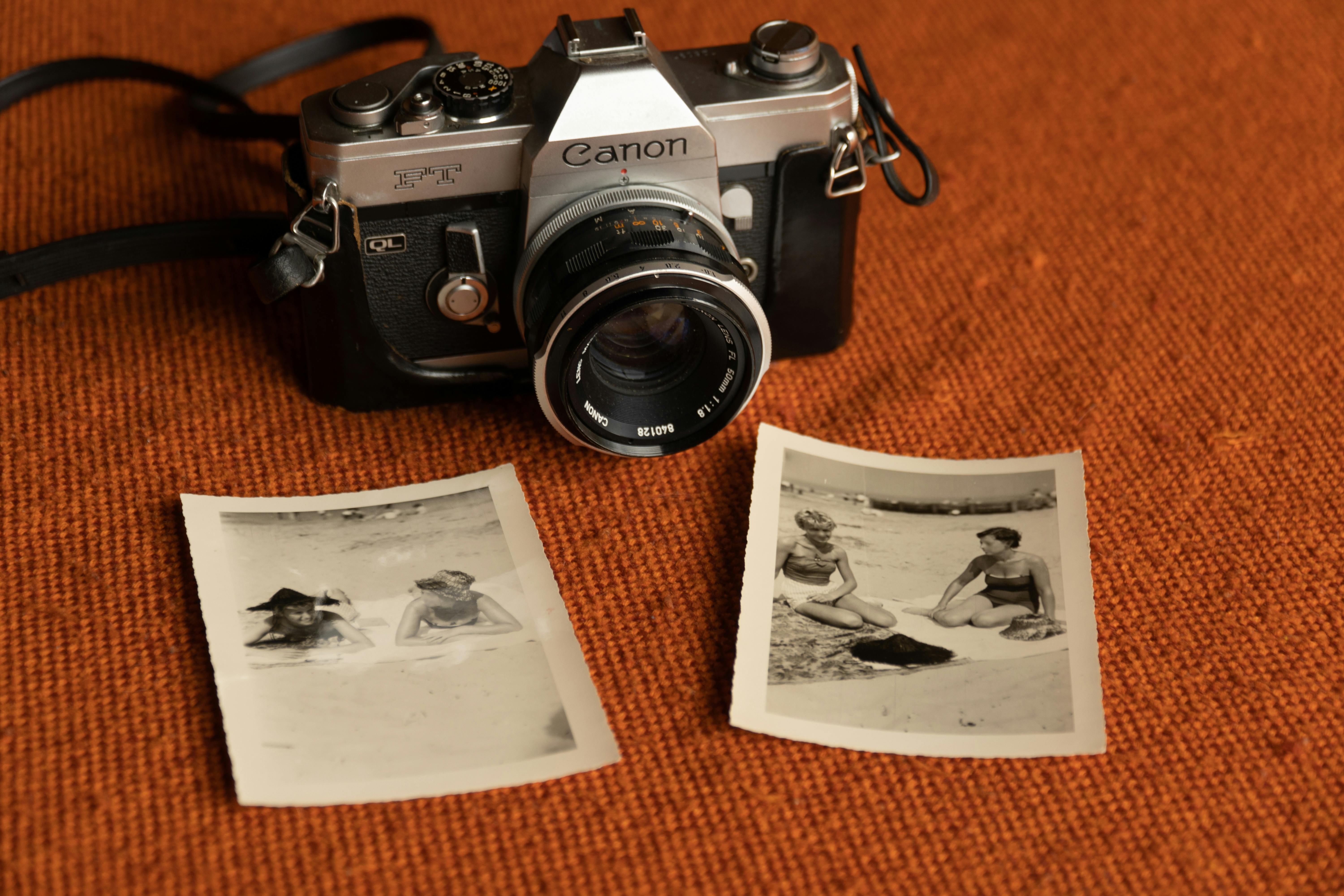 A classic Canon camera alongside nostalgic beach photographs, evoking memories of the past.