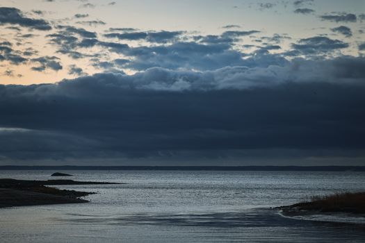 A tranquil view of Stamford Sound at sunrise with dramatic clouds over calm waters, creating a serene atmosphere.