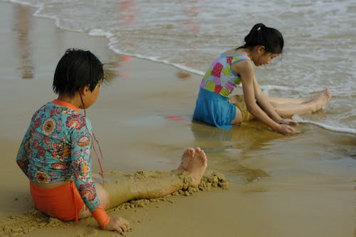 Children Playing with Sand on a Beach