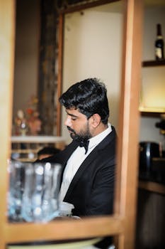 Thoughtful man with short hair in a suit, captured indoors at a stylish bar.