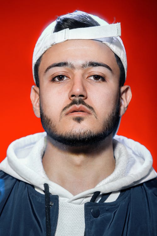 Studio Portrait of a Young Man in a Hoodie and Wearing a Cap Backwards 