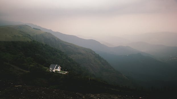 Stunning landscape view of a house nestled in the misty mountains of Idukki, India.