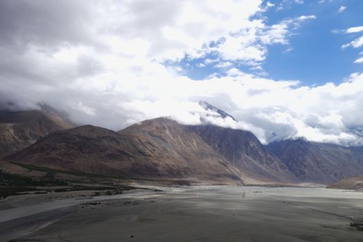 Serene mountain range under dramatic clouds, ideal for nature and travel themes.