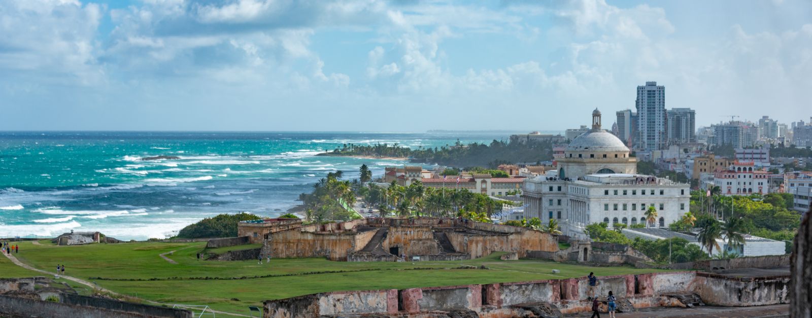 Explore the stunning view of San Juan's historic fort with ocean backdrop under a vibrant sky.