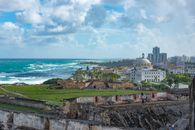 Explore the stunning view of San Juan's historic fort with ocean backdrop under a vibrant sky.