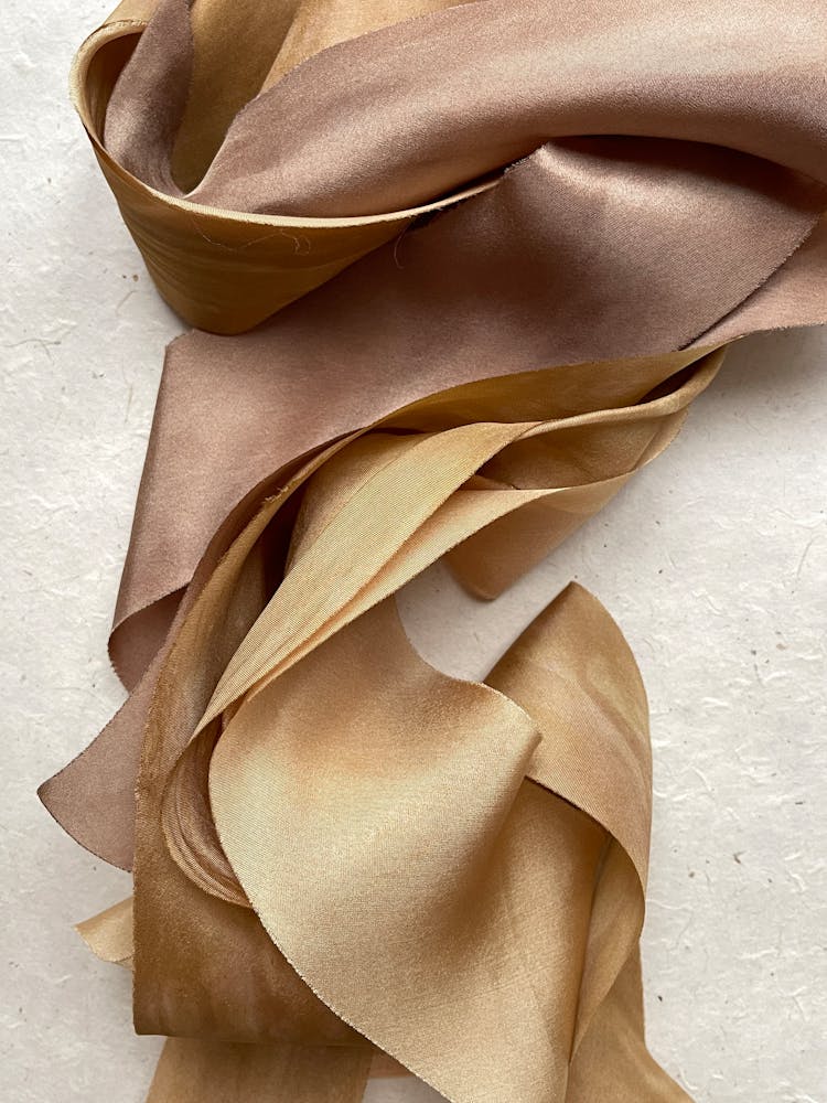 Gold Satin Fabric On A White Surface